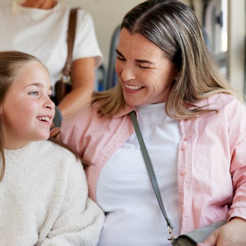 Young daughter and mum travelling on a bus together