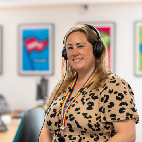 A female Money Adviser in one of HPG's offices with a headset on ready to speak with and support customers.