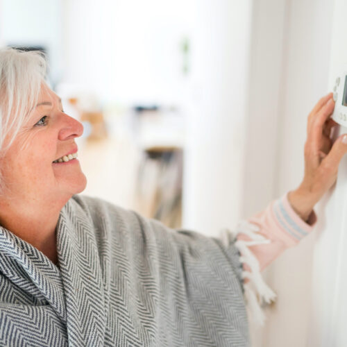 Woman adjusting her thermostat