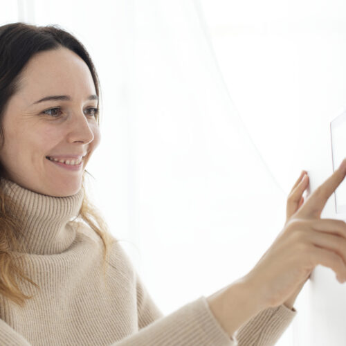 Woman pressing smart home monitor